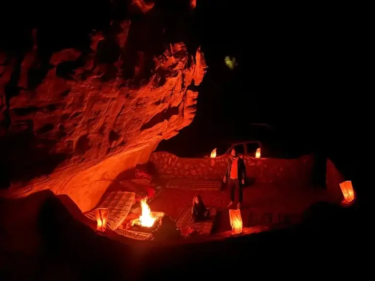 Campfire inside a cave in Wadi Rum with a cozy Bedouin setup at night