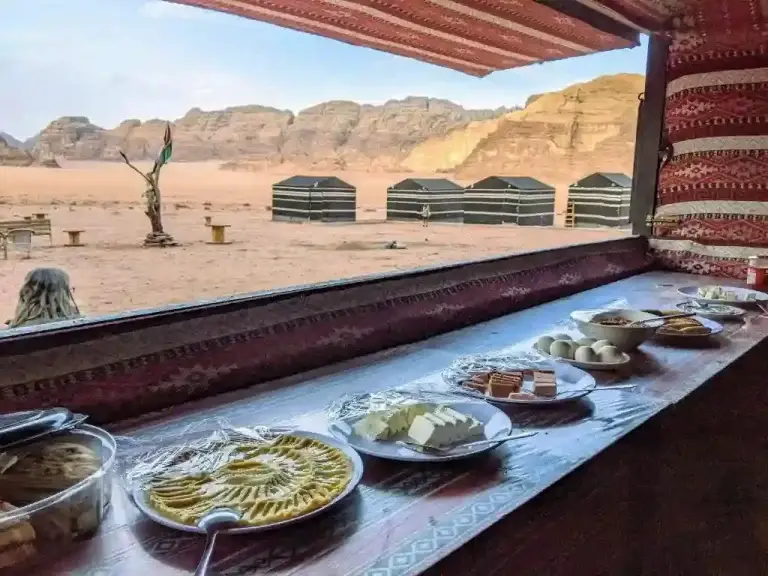 Traditional Bedouin meal served on a table inside a tent with desert views in Wadi Rum