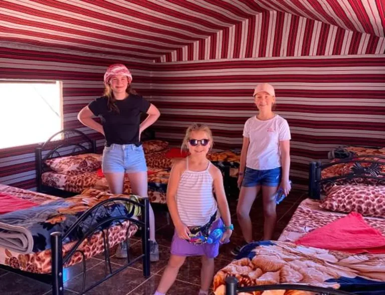A happy family inside a traditional Bedouin tent at Salem Camp, Wadi Rum.